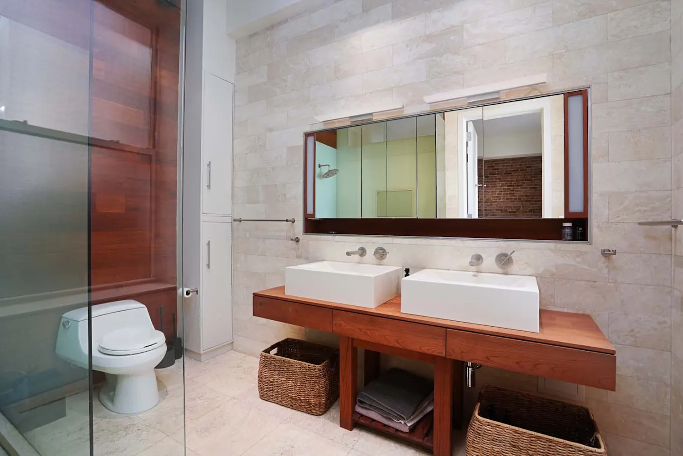 Bathroom with double vanity and stone wall