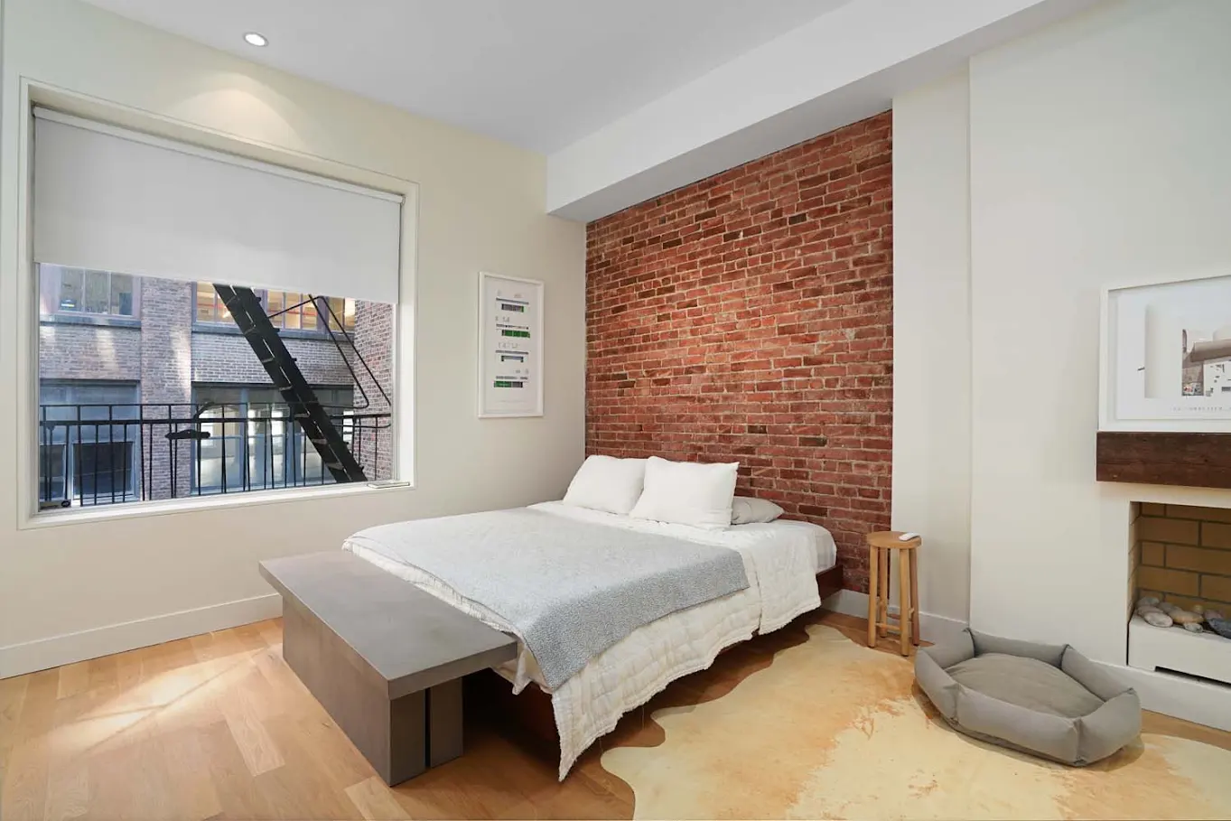 Bedroom with exposed brick and fireplace